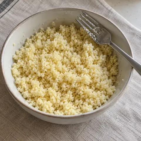 Étape 4 : Préparez la semoule avec le même volume d’eau bouillante, couvrez 5 minutes, puis égrenez-la avec le reste d’huile.