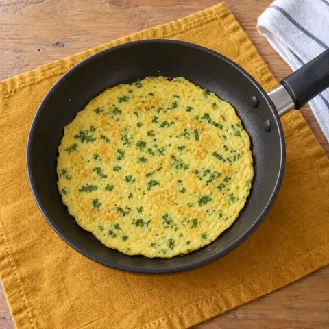 Étape 3 : Le jour du repas, battez l’œuf avec le lait, le persil et la ciboulette. Faites fondre le beurre dans une petite poêle antiadhésive, versez l’œuf en une fine couche et faites cuire 3 minutes à couvert, à feu doux. Retournez l’omelette et faites cuire encore 2 minutes : elle doit être bien cuite partout, sans aucune partie liquide ni brillante.