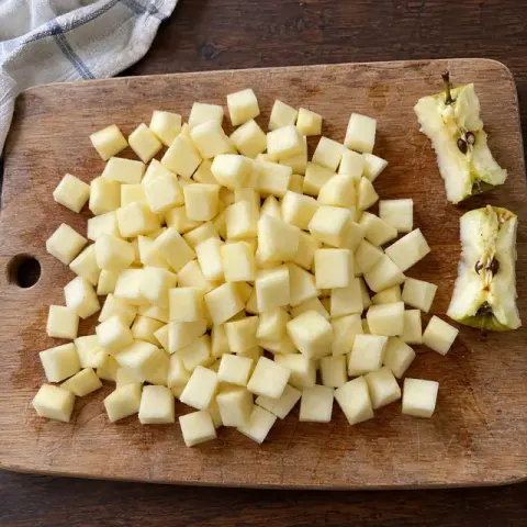 Étape 1 : Préchauffez le four à 180 °C. Épluchez les pommes, coupez-les en quartiers, retirez le cœur et les pépins, puis coupez-les en dés d’1,5 cm.