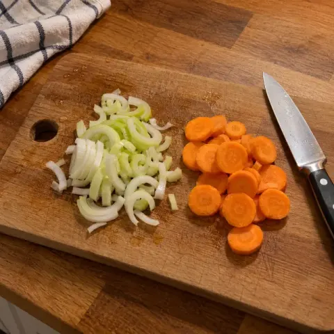 Étape 1 : Fendez le blanc de poireau en deux dans la longueur, rincez-le en écartant les feuilles, puis émincez-le ; coupez les carottes en rondelles.