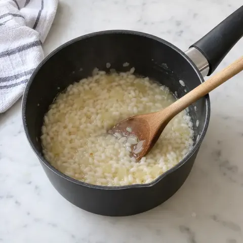 Étape 1 : Mettez le riz et l’oignon dans une petite casserole avec 150 ml d’eau chaude. Laissez cuire à feu doux en remuant souvent.